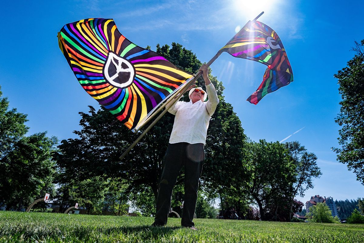 Patrick Devine spins Pride-inspired peace flags Saturday during the Pride in the Park event in Coeur d’Alene Park.  (COLIN MULVANY/THE SPOKESMAN-REVIEW)