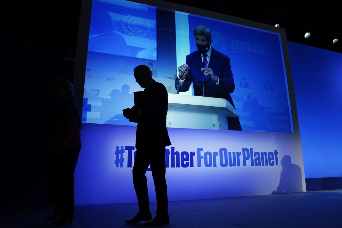 President Joe Biden walks off after speaking during an event about the "Global Methane Pledge" at the COP26 U.N. Climate Summit, Nov. 2, 2021, in Glasgow, Scotland, as John Kerry, United States Special Presidential Envoy for Climate is seen taking the podium, as shown on the screen. Kerry, President Barack Obama