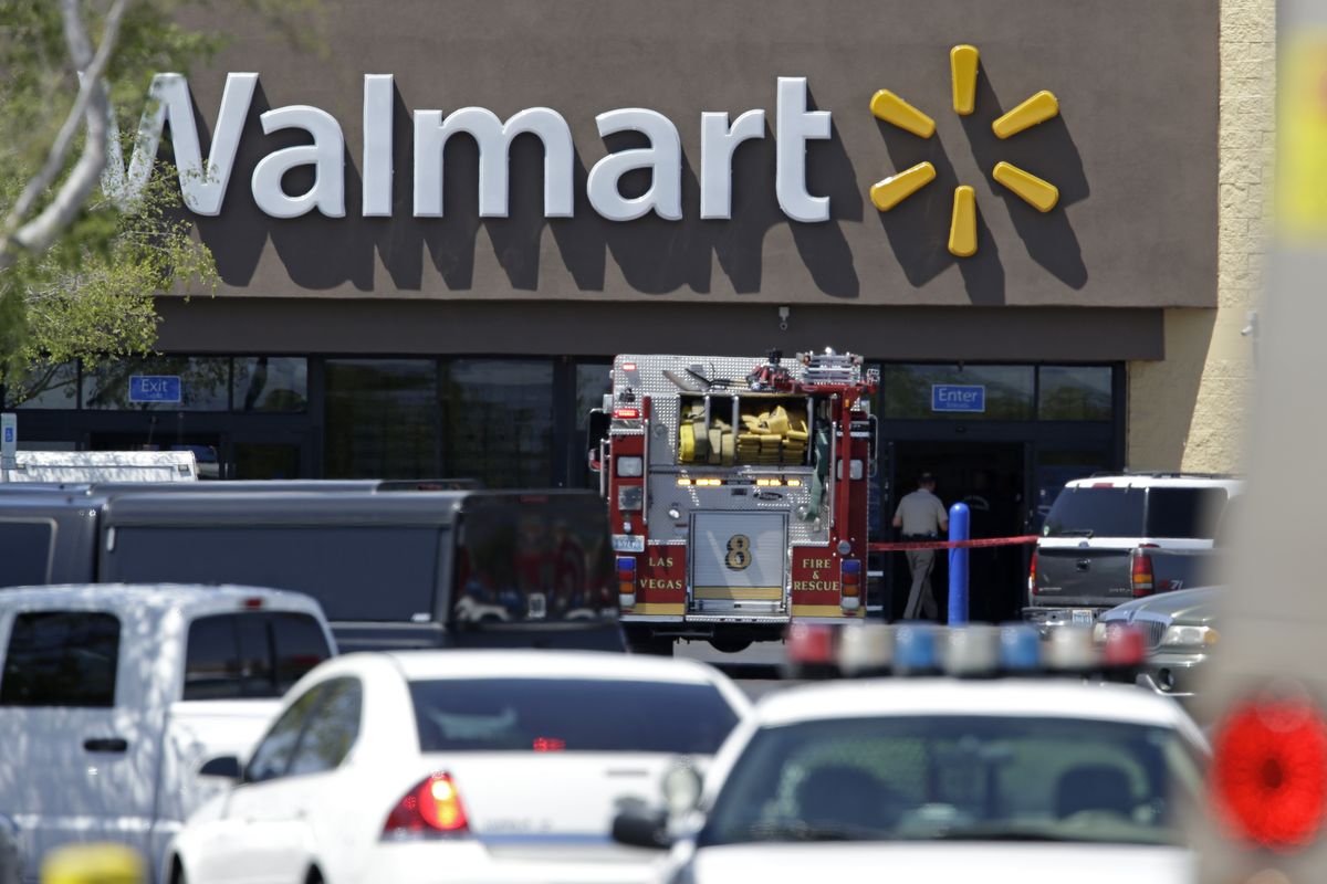 Police and firefighters appear on the scene of a shooting at a Wal-Mart in Las Vegas on Sunday. Police say two suspects shot two officers at a pizza parlor before fatally shooting a person and turning the guns on themselves at the Wal-Mart. (Associated Press)