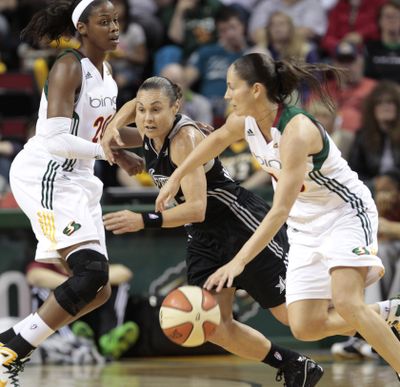 Seattle’s Camille Little, left, sets a pick for Sue Bird, right, as San Antonio’s Tully Bevilaqua defends. (Associated Press)