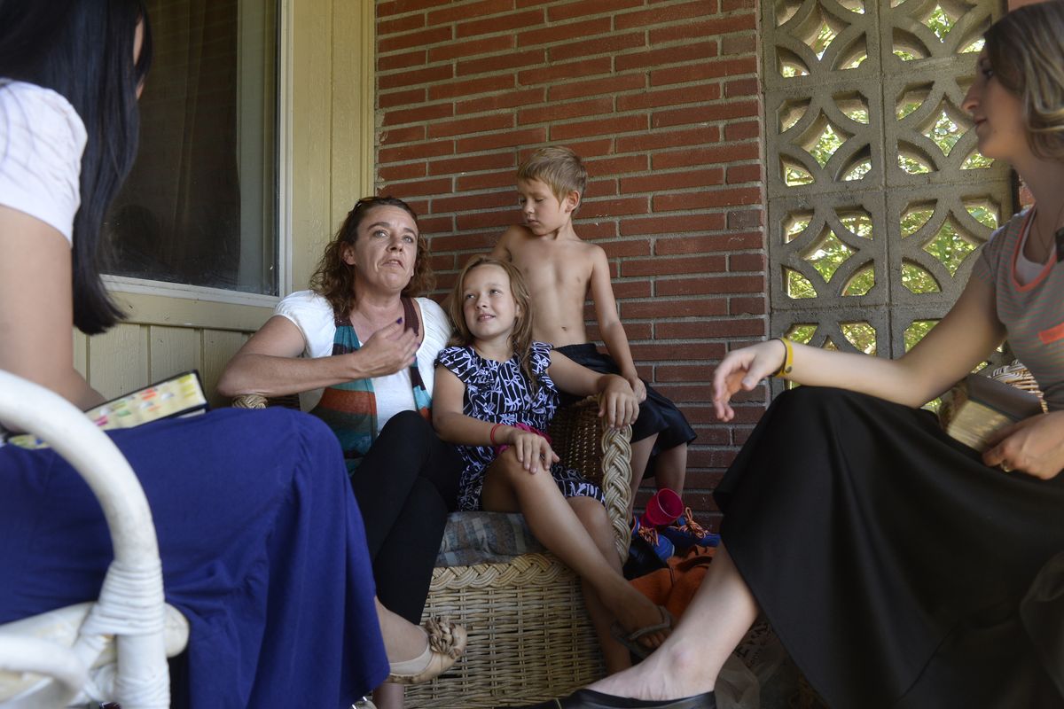 April Dionne, center, sitting with her children Zoee, 8, and Richard, 7, talks with Huang and Becraft about her search for spiritual fulfillment on July 29.