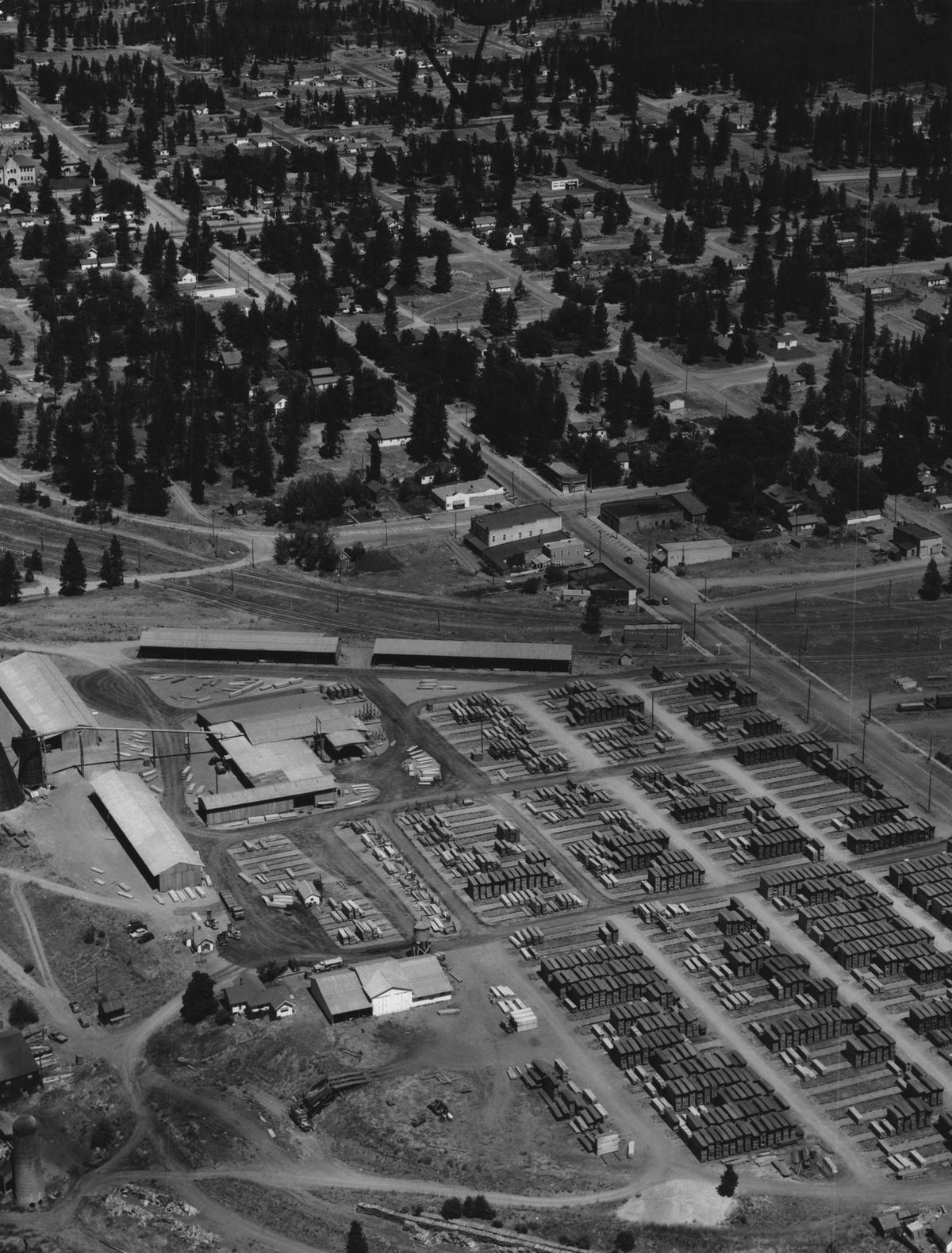 This aerial view of the Post Falls Lumber Co., circa 1950,  shows stacks of milled lumber surrounded by the sparse residential density of the little town that grew up around the busy mill, originated by namesake pioneer Frederick Post in the late 1880s. The mill was shut down around 1995 by Louisiana-Pacific Corp., which was downsizing after lawsuits over its failed house siding products. It was sold to developer Harry Green in 2001. The project went into bankruptcy in 2007. Gene Scamahorn Photography/The Spokesman-Review Photo Archive (Gene Scamahorn Photography via The Spokesman-Review Photo Archive / Scamahorn Aerial Photo)