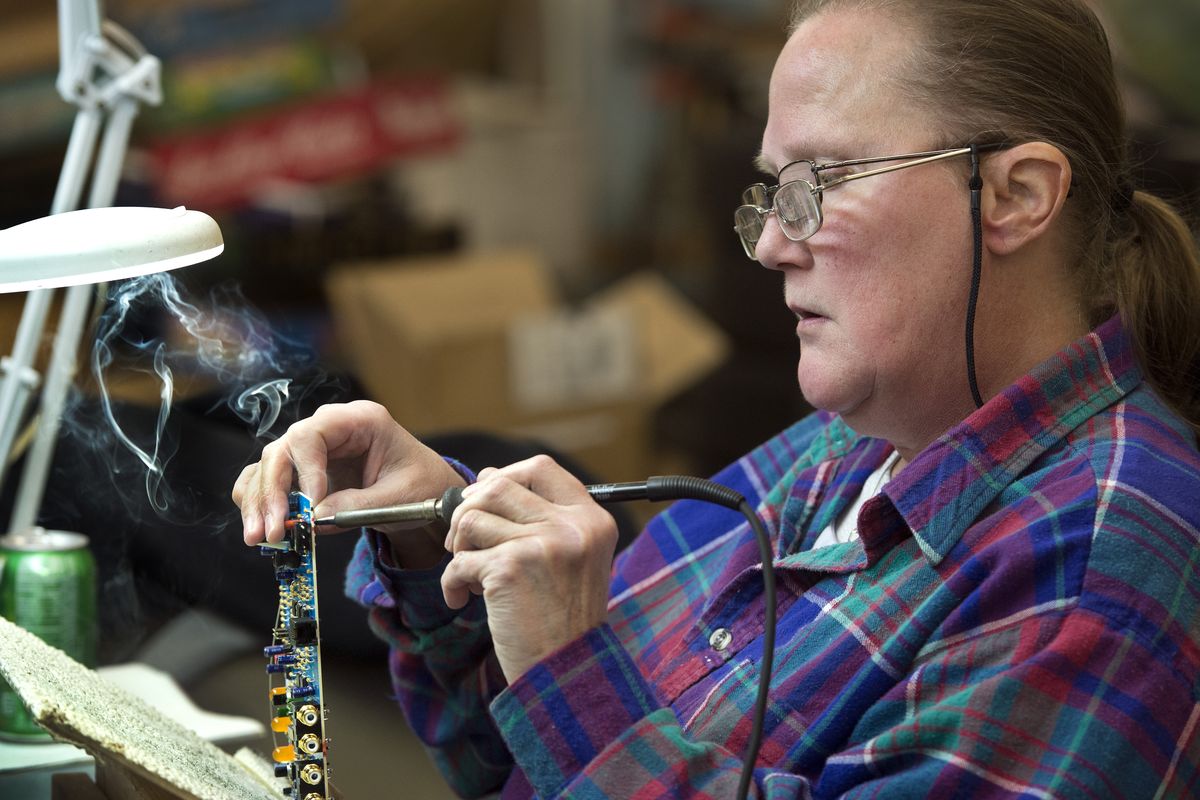 JoLynn Gamble, rework touch-up operator at AudioControl, cleans up a circuit board before it is shipped from their facility on East Francis Avenue in Spokane on Wednesday. The board is used for upgrading auto audio systems. (Dan Pelle)