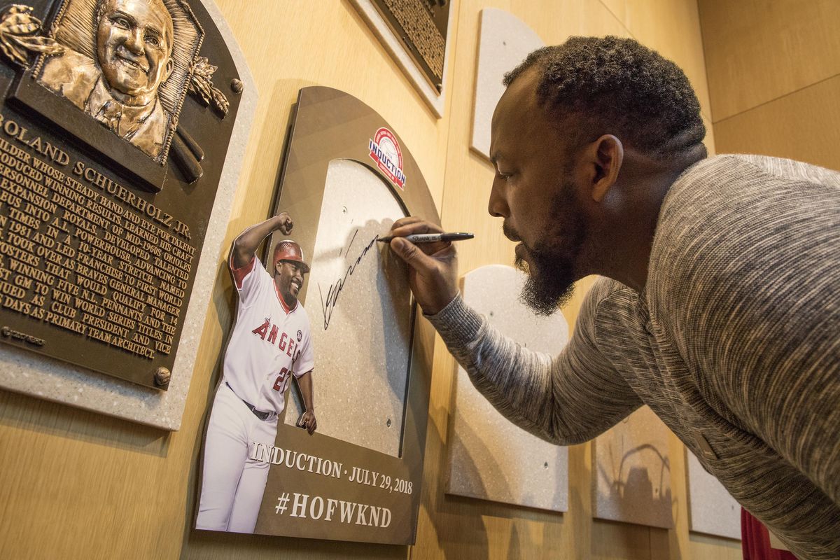 Vladimir Guerrero signs the spot where his Baseball Hall of Fame plaque will hang during a visit to the hall Thursday  in Cooperstown, N.Y. Guerrero, a native of the Dominican Republic, was elected to the Hall of Fame in January. (Milo Stewart Jr. / AP)