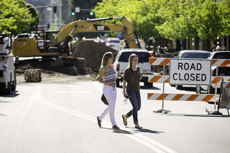 Lexi Carlsen, left, and Caitlin McHugh cross Sherman Avenue Friday while browsing Coeur d'Alene retail shops. Construction on McEuen Park has affected parking and driving routes downtown. (Shawn Gust/press)