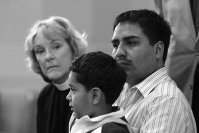 
Rene Martinez, right, holds his son Rodrigo Martinez, 4, as Susan Armer, rector of St. Mathew/San Mateo Episcopal Church, looks on Wednesday at St. Mark's Episcopal Cathedral in Seattle. 
 (Associated Press / The Spokesman-Review)
