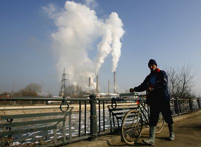 A man pushes his bike Wednesday past one of the main heating plants in Bucharest, Romania.  A pipeline bringing Russian gas to Romania through Ukraine was turned off Wednesday morning.  (Associated Press / The Spokesman-Review)