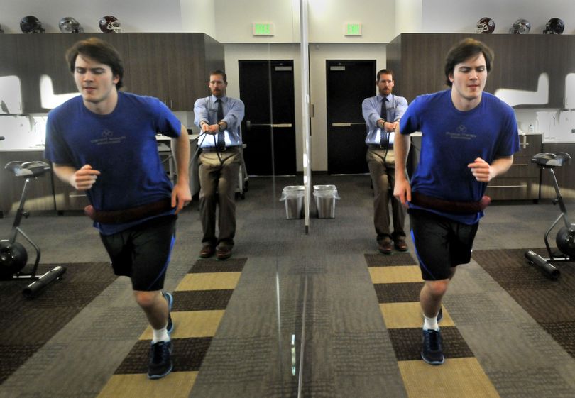 Three months after surgery to repair his ACL, G-Prep junior Reed Hopkins pulls against resistance of physical therapist Craig Henneberry. (JESSE TINSLEY PHOTOS)