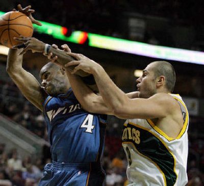 
Washington's Antawn Jamison, left, has his arm grasped by Seattle's Vitaly Potapenko as they vie for a rebound during the first quarter.
 (Associated Press / The Spokesman-Review)