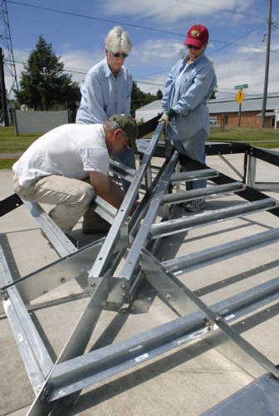 
Becky Obernolte, left, and Ann Cowley lift a skating ramp as Jep Edwards attaches hardware at the Fairfield skate park.
 (Dan Pelle / The Spokesman-Review)