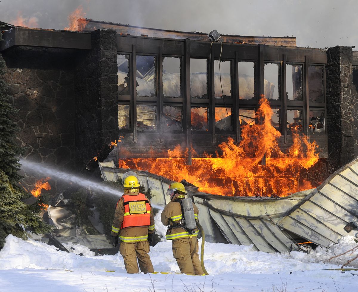 Firefighters Barry Roach and Jeff Betz do their best to help prevent fire from spreading from the main entry of the Seventh-day Adventist headquarters to the administrative wing of the building Sunday, Dec. 28, 2008, at 3715 S. Grove near Spokane.   (Dan Pelle / The Spokesman-Review)
