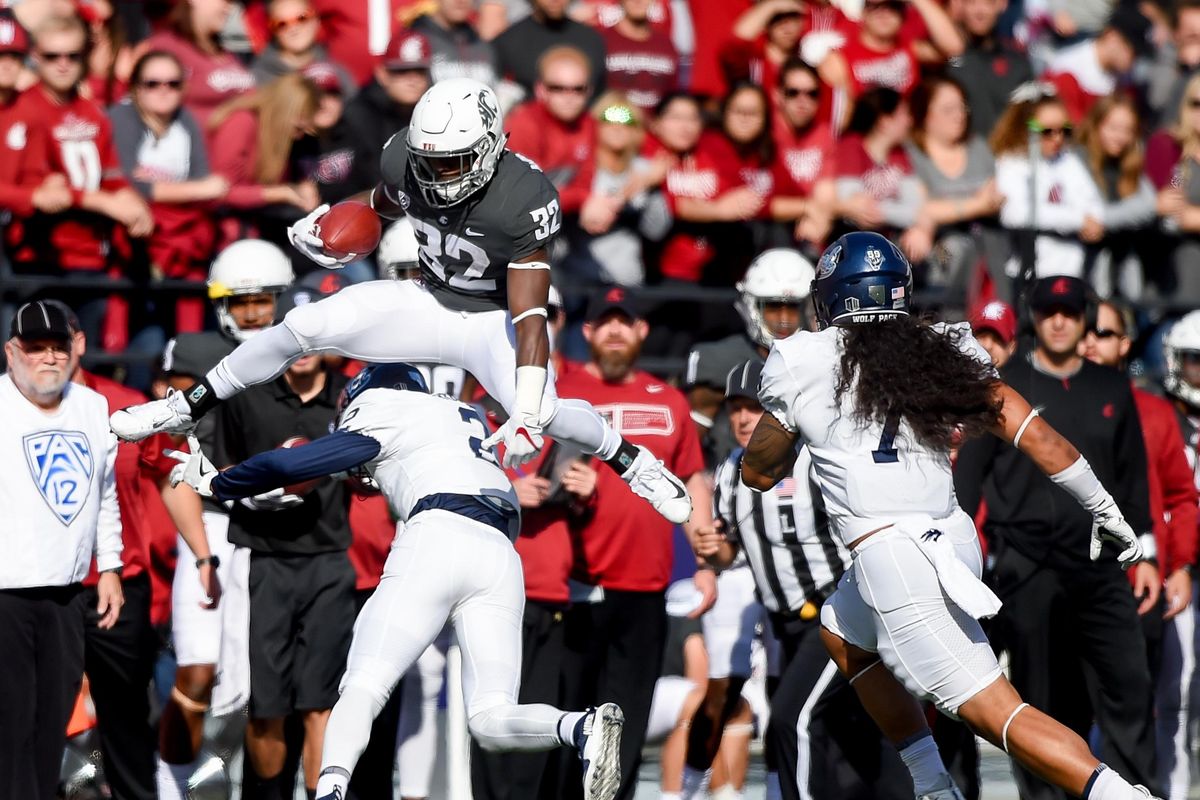 Washington State Cougars running back James Williams (32) hurdles Nevada Wolf Pack defensive back Asauni Rufus (2) during the first half of an NCAA college football game on Saturday, Sept. 23, 2017, at Martin Stadium in Pullman. (Tyler Tjomsland / The Spokesman-Review)