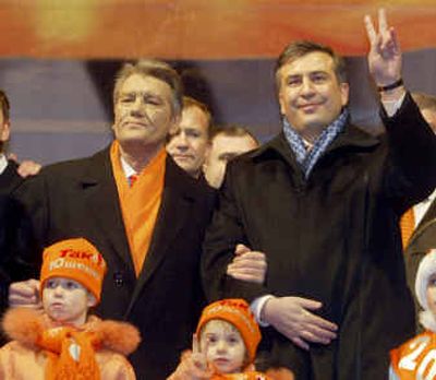 
Viktor Yushchenko who soundly won Sunday's presidential revote, left, and visiting Georgian President Mikhail Saakashvili greet the crowd in Independence square in Ukraine's capital Kiev on the occasion of the New Year celebration. Yushchenko's daughters are seen in the foreground. 
 (Associated Press / The Spokesman-Review)