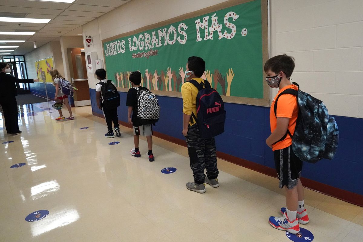 In this Sept. 3, 2020 photo, students keep social distance as they walk to their classroom in Highwood, Ill., part of the North Shore school district. In response to a push for culturally responsive teaching that gained steam following last year