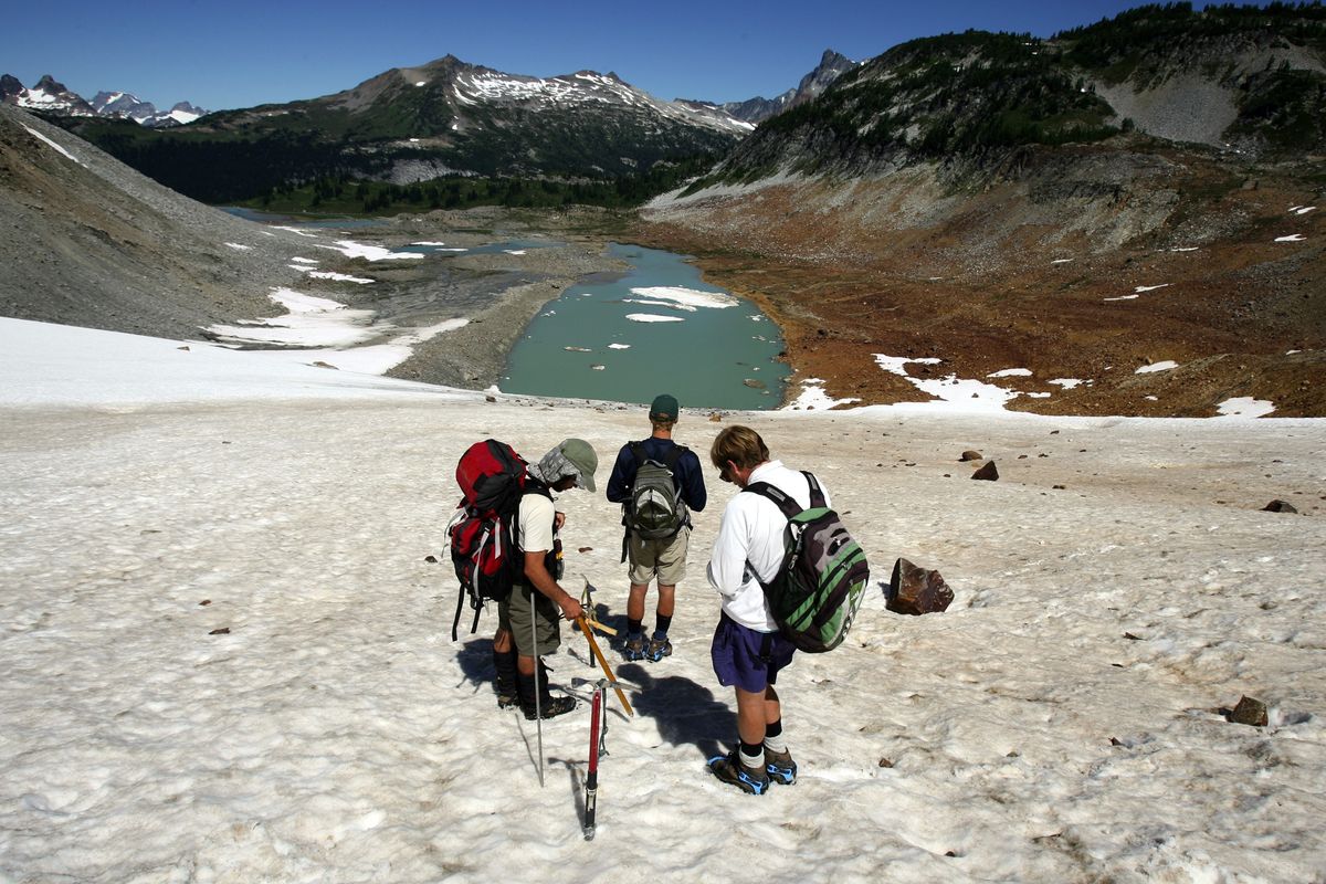 Mauri Pelto, right, records GPS readings and snow levels on Lyman Glacier in the North Cascades on Aug. 11, 2008. The glacier has shrunk from near where ice floats in glacier water below. (Associated Press / The Spokesman-Review)