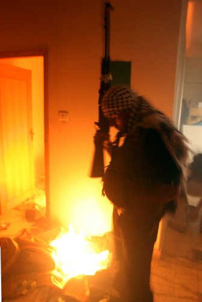 
A Fatah militant sets the offices of a Hamas-affiliated charity on fire in the West Bank city of Nablus on Friday. Associated Press
 (Associated Press / The Spokesman-Review)