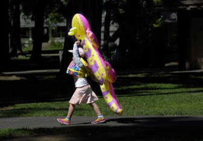 
Rachel Tucker, 6, of Spokane, carries her lizard water toy through Coeur d'Alene City Park on her way to Lake Coeur d'Alene on Thursday.  She and her family were beating the heat by spending a day near the water. 
 (Kathy Plonka / The Spokesman-Review)