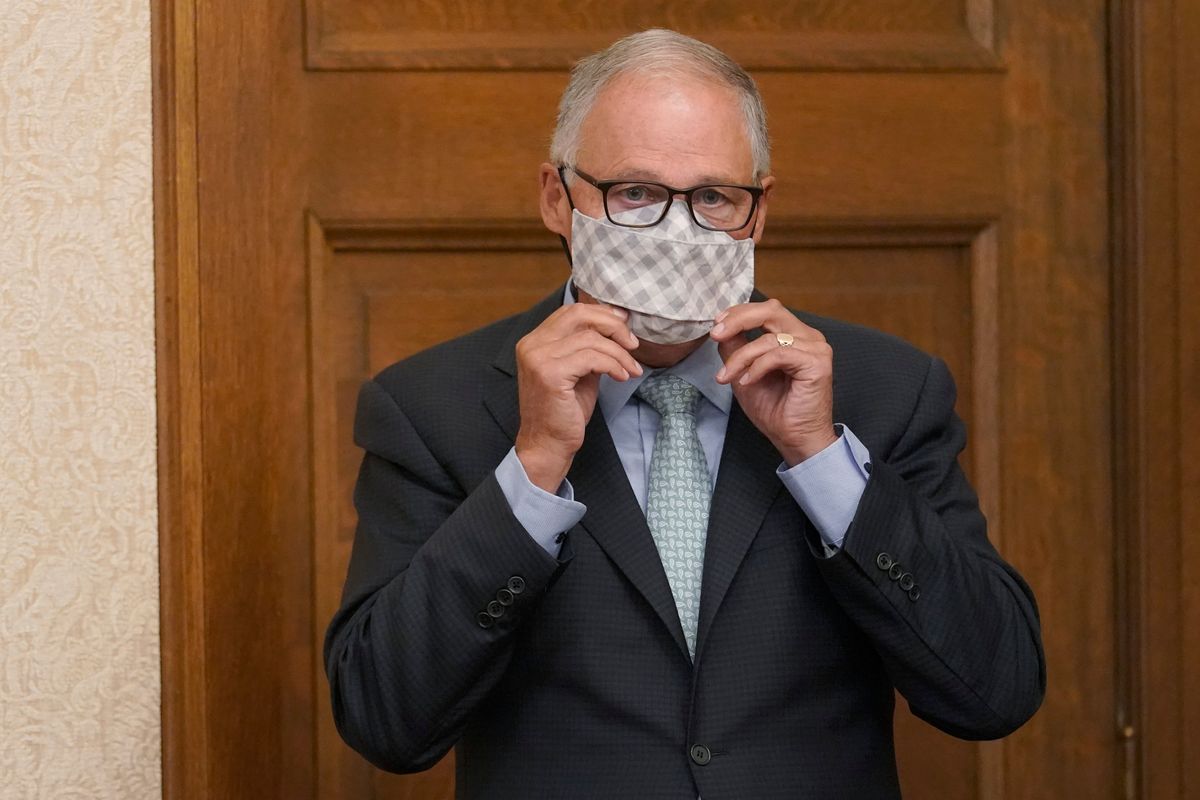 Washington Gov. Jay Inslee puts on a mask after speaking at a news conference Aug. 18, 2021, at the Capitol in Olympia.  (Associated Press)