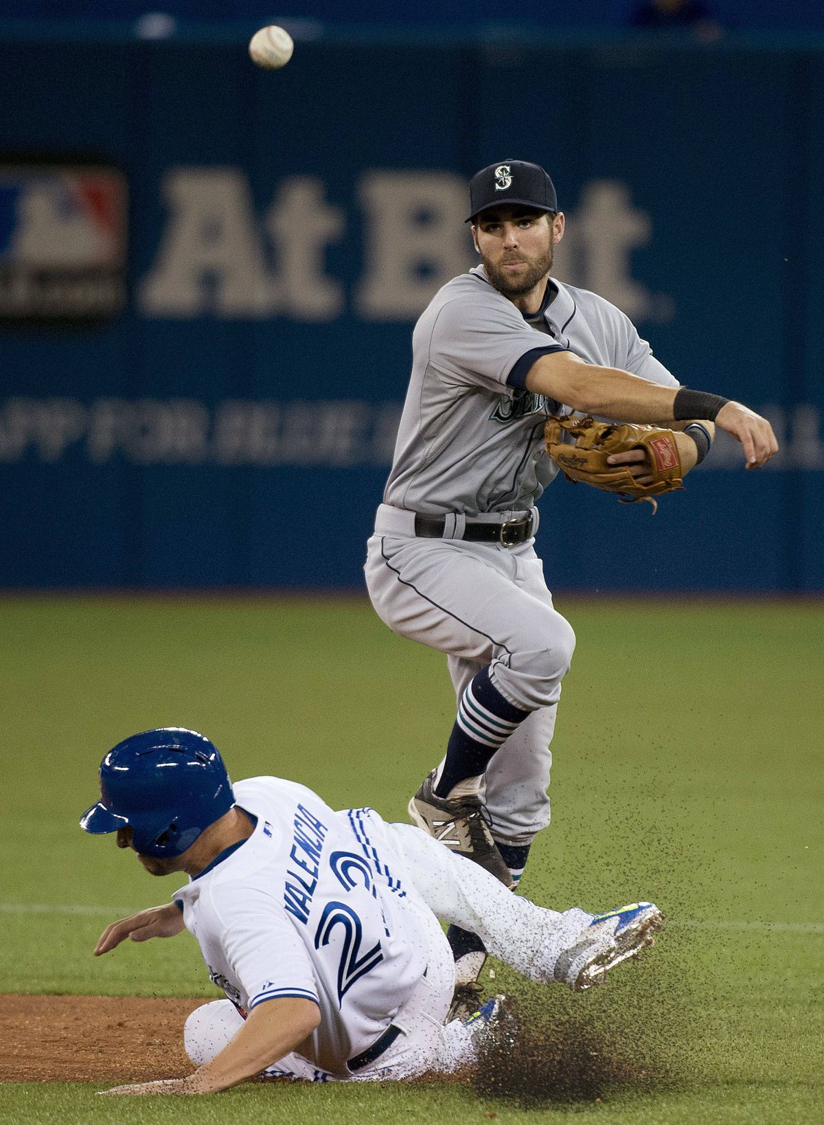 Seattle’s Chris Taylor throws to first over Danny Valencia. (Associated Press)