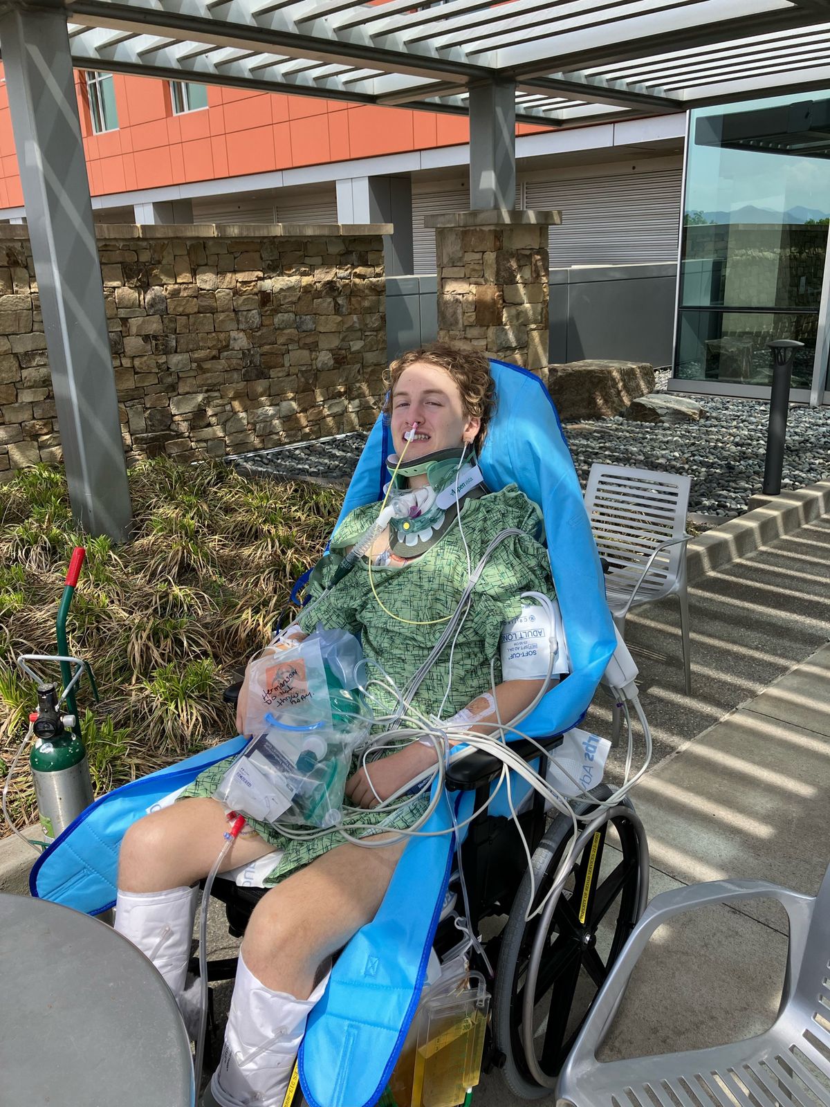Alex Hermanson flashes a smile to his family members outside Mission Hospital in Asheville, N.C., last week, while on his first visit outdoors in more than two weeks. The Spokane-raised mountain biker could return as soon as next week. (Nick Gibson / The Spokesman-Review)
