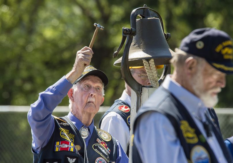 Tom DePew, WWII U. S. Navy submariner, rings the bell as the names of ships lost to war are read aloud during the Laying of the Wreath Ceremony, May 29, 2017, on Honeysuckle Beach in Hayden Lake, Idaho. (Dan Pelle / The Spokesman-Review)