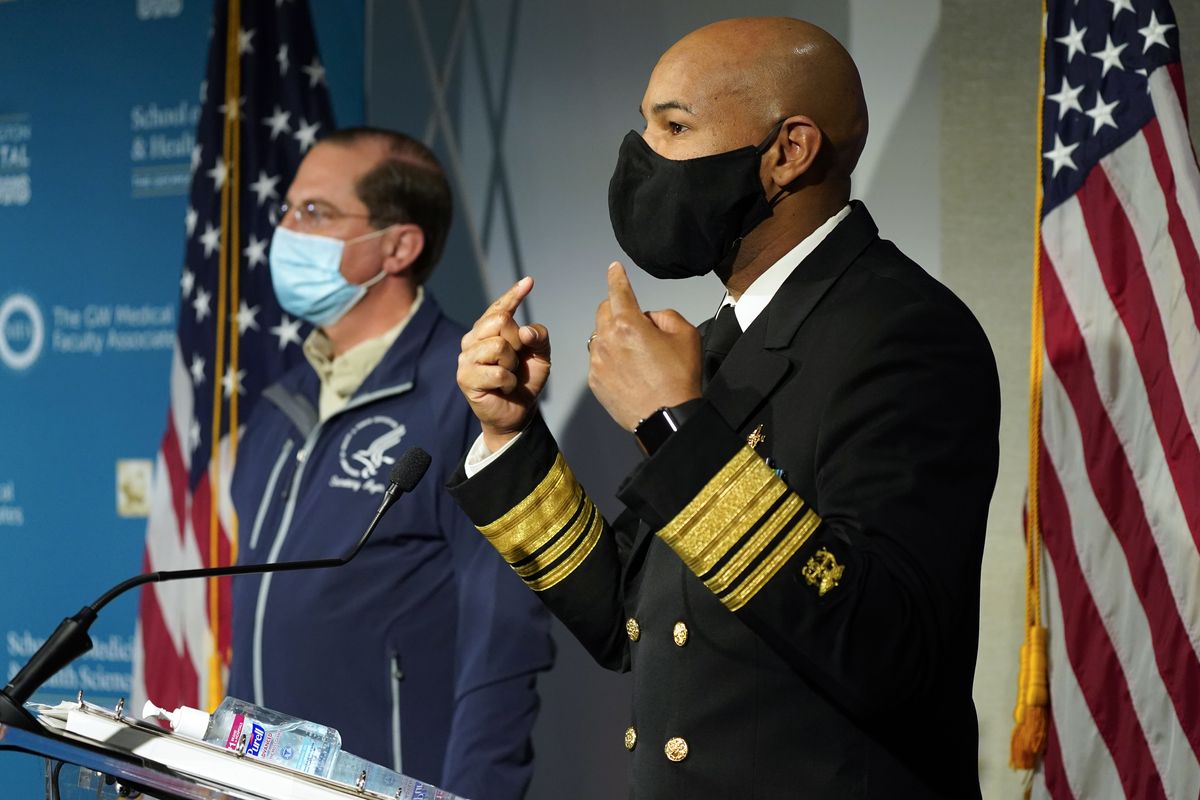 U.S. Surgeon General Dr. Jerome Adams talks about the need to wear face masks as he speaks at George Washington University Hospital on Monday in Washington, D.C., as Health and Human Services Secretary Alex Azar listens.  (Jacquelyn Martin/Associated Press)