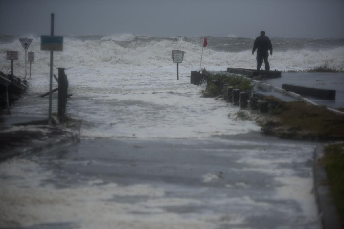 A man stands in front of storm surges in Myrtle Beach, S.C., on Sept. 30, 2022. (Melissa Sue Gerrits/For The Washington Post)