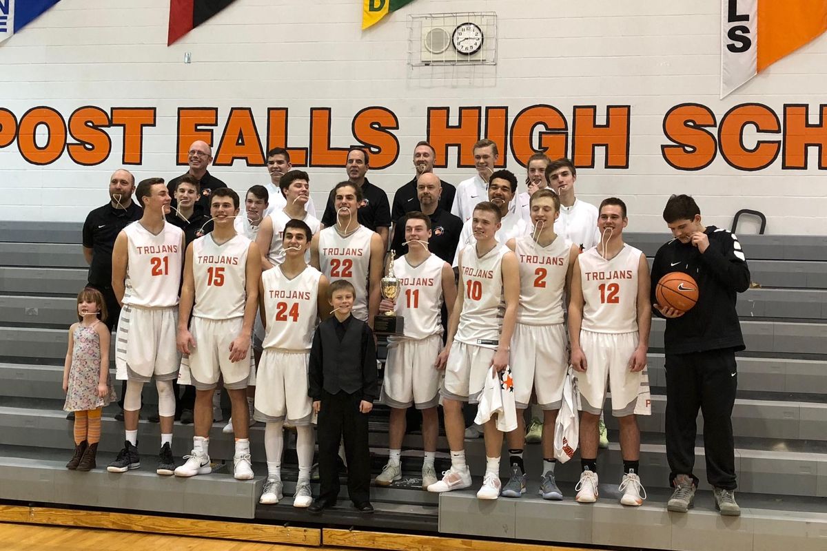The Post Falls boys team poses with the Idaho 5A District 1-2 championship trophy after knocking off Coeur d’Alene 56-31 on Tuesday at Post Falls HS. (Dave Nichols / The Spokesman-Review)