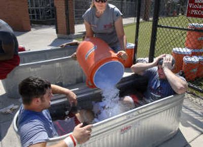 
Jessica Vaughan dumps a bucket of ice into a tub much to the displeasure of Brady Emmons, left, and Alex Hamill (Lake City). 
 (Dan Pelle / The Spokesman-Review)