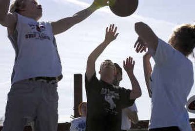 Hutton Settlement's Brian Haffner, 14, far left, and Pamela Smith, 14, far right, block Gonzaga University Special Olympics athlete Jacob Renner, middle, during practice at St. Aloysius Elementary School.
(Liz Kishimoto / The Spokesman-Review)