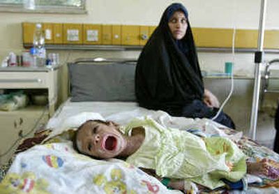 
 Rahab Ali al-Musawi, 18, looks on while her 3-month-old son Ali Mohammed cries during his treatment for diarrhea in the General Teaching Hospital for Children, Thursday in Baghdad, Iraq.
 (Associated Press / The Spokesman-Review)