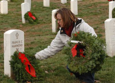 
Penny Bradshaw, of Lake Forest, Calif., places a wreath at the headstone of Medal of Honor recipient Francis C. Hammond on Saturday in Arlington National Cemetery. Associated Press
 (Associated Press / The Spokesman-Review)