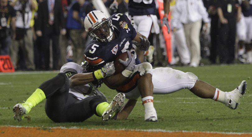 Auburn's Michael Dyer (5) is tackled short of the goal line by Oregon's Eddie Pleasant (11) defends during the second half of the BCS National Championship NCAA college football game Monday, Jan. 10, 2011, in Glendale, Ariz. Auburn won 22-19. (Matt York / Associated Press)