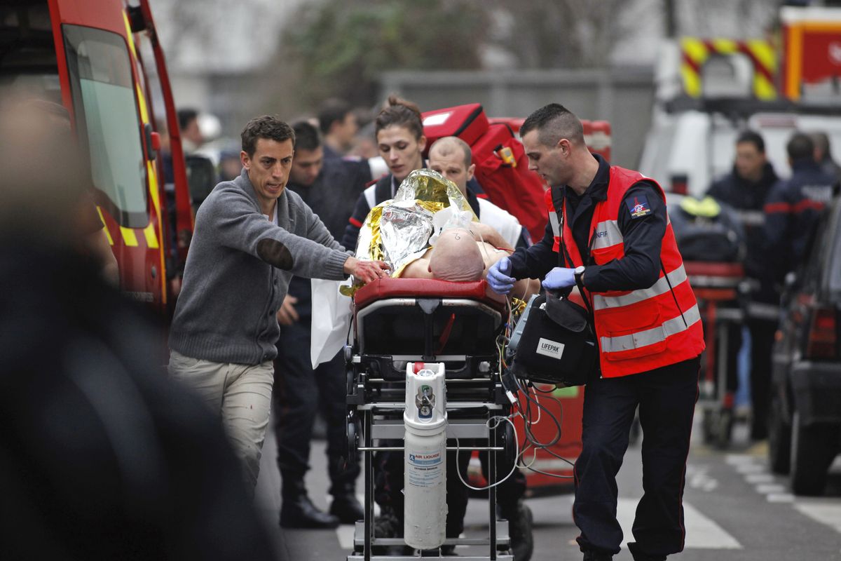 FILE - In this Jan. 7, 2015 file photo, an injured person is transported to an ambulance after a shooting at the French satirical newspaper Charlie Hebdo