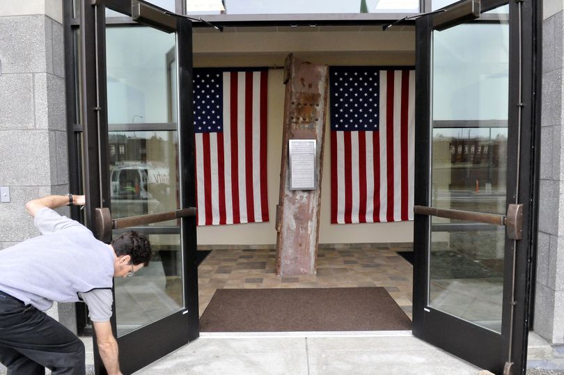 Joseph Yacker opens the front door of the new Spokane Valley Fire administration building Monday, to show the prominent display of a beam from the World Trade Center in the entryway. Yacker works with information systems in the building. (Jesse Tinsley)