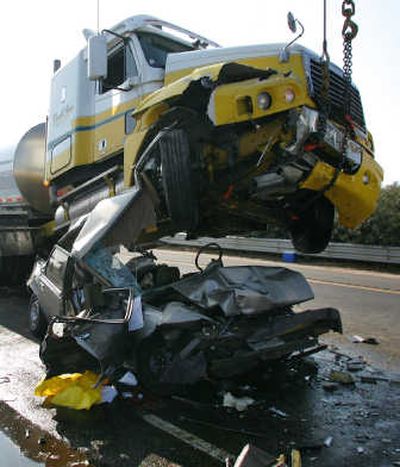 
A tow truck lifts a  semi-truck from the top of a crushed car Saturday  on Highway 99  in Fresno, Calif. Associated Press
 (Associated Press / The Spokesman-Review)