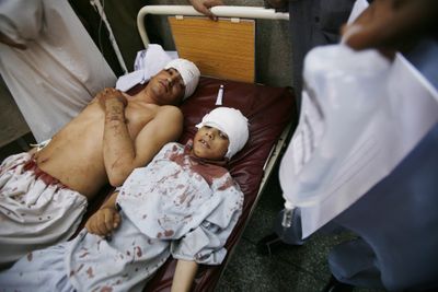 An injured man and boy are treated in a hospital after a bomb explosion in Peshawar, in northwest Pakistan, on Saturday.  (Associated Press / The Spokesman-Review)