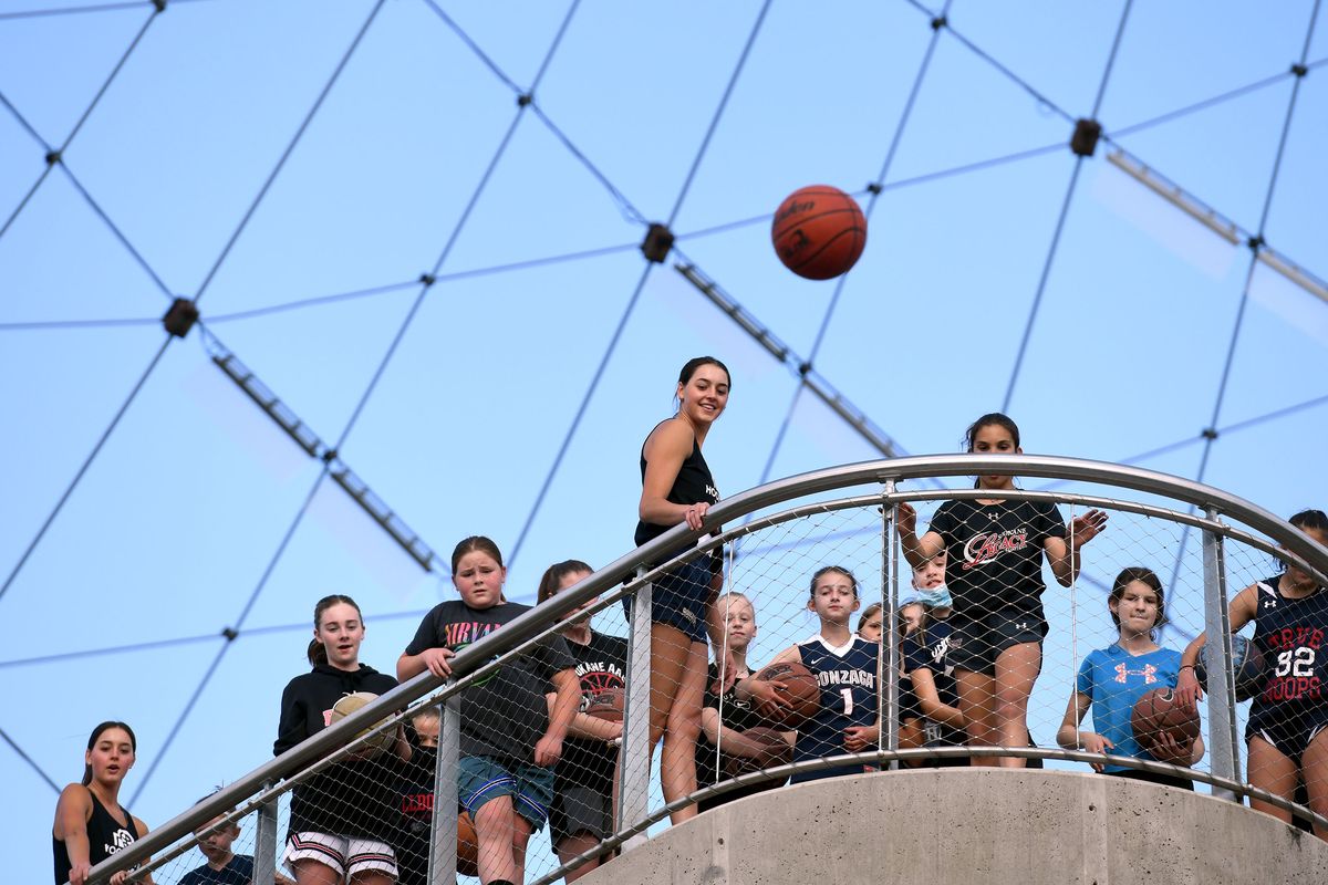 Jenn Wirth watches an attempt at making a shot into a hoop from the top lookout at the Pavilion at Riverfront Park in Spokane on Monday, May 10, 2021. Jenn and her twin sister LeeAnne, far left, former Gonzaga basketball standouts, offered two basketball clinics put on by Hooptown USA.  (Kathy Plonka/The Spokesman-Review)