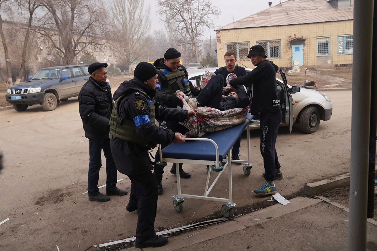 Ukrainian servicemen and volunteers carry a man injured during a shelling attack into hospital number 3 in Mariupol, Ukraine, Tuesday, March 15, 2022.  (Evgeniy Maloletka)