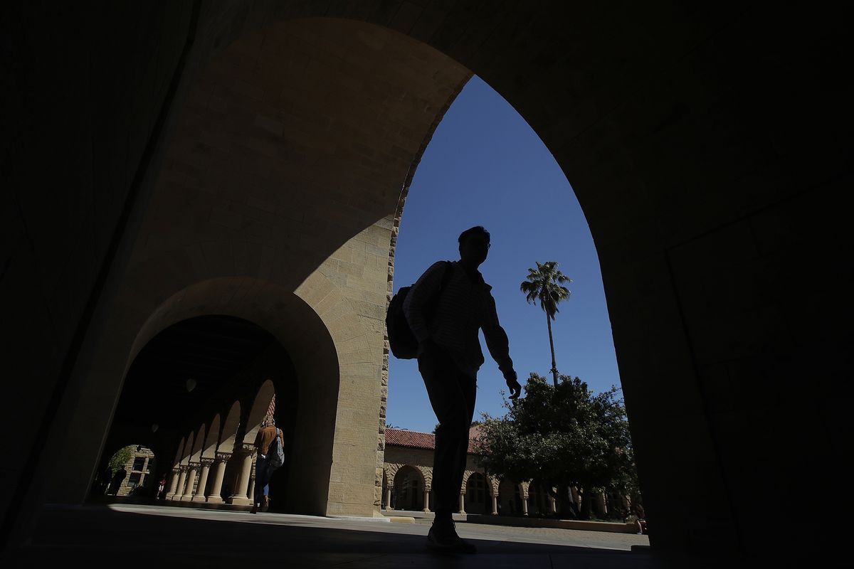 FILE - In this April 9, 2019, file photo, pedestrians walk on the campus at Stanford University in Stanford, Calif. Thousands of public servants who were rejected from a student loan forgiveness program will get their cases reviewed by the Education Department as part of a new settlement in a lawsuit brought by one of the nation
