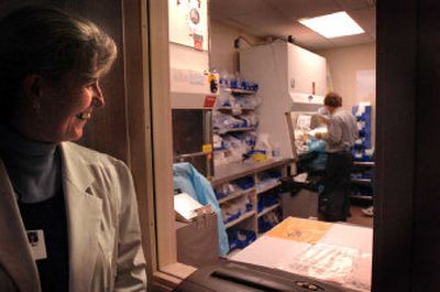 
 Cindy Johnson watches pharmacy technicians mix drugs for chemotherapy in a special room at the North Idaho Cancer Center, where ventilation hoods protect workers from toxic fumes. 
 (Jesse Tinsley / The Spokesman-Review)