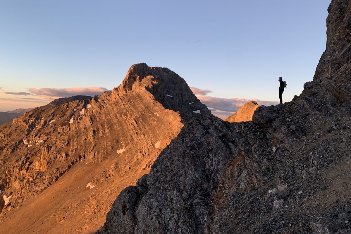 Daniel Todd looks on as early morning light comes over the Riddler, one of 15 peaks in the Lemhi Range that Todd and climbing partner Haylee Stocking traversed in 26 hours.  (Courtesy of Daniel Todd)