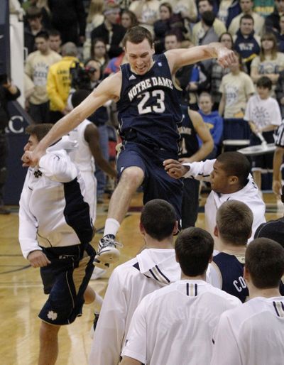 Notre Dame's Ben Hansbrough leaps toward his teammates as they greet him after the Irish defeated No. 2 Pittsburgh.  (Associated Press)