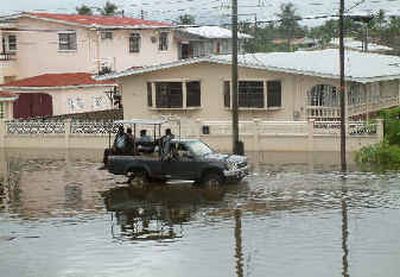 
Members of the Guyana Police Force patrol to prevent looting on a flooded street.  
 (Associated Press / The Spokesman-Review)