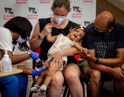 Nurse Reisa Lancaster administers coronavirus vaccine to 14-month-old Ada Hedge as she is comforted by her mother, Sarah Close, and father, Chinmay Hedge, on June 21 in Washington, D.C.  (Bill O'Leary/Washington Posst)