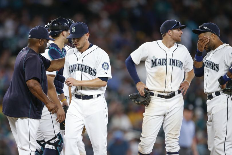 Mariners pitcher Rob Rasmussen, third from left, leaves the mound after failing to get an out in the 11th. (Associated Press)