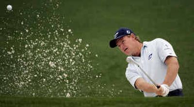 Ernie Els, hitting out of sand on the second hole, is struggling at Augusta but still managed to just make the cut with a 10-foot putt on the 18th green to close out his second round Saturday.
(Associated Press / The Spokesman-Review)