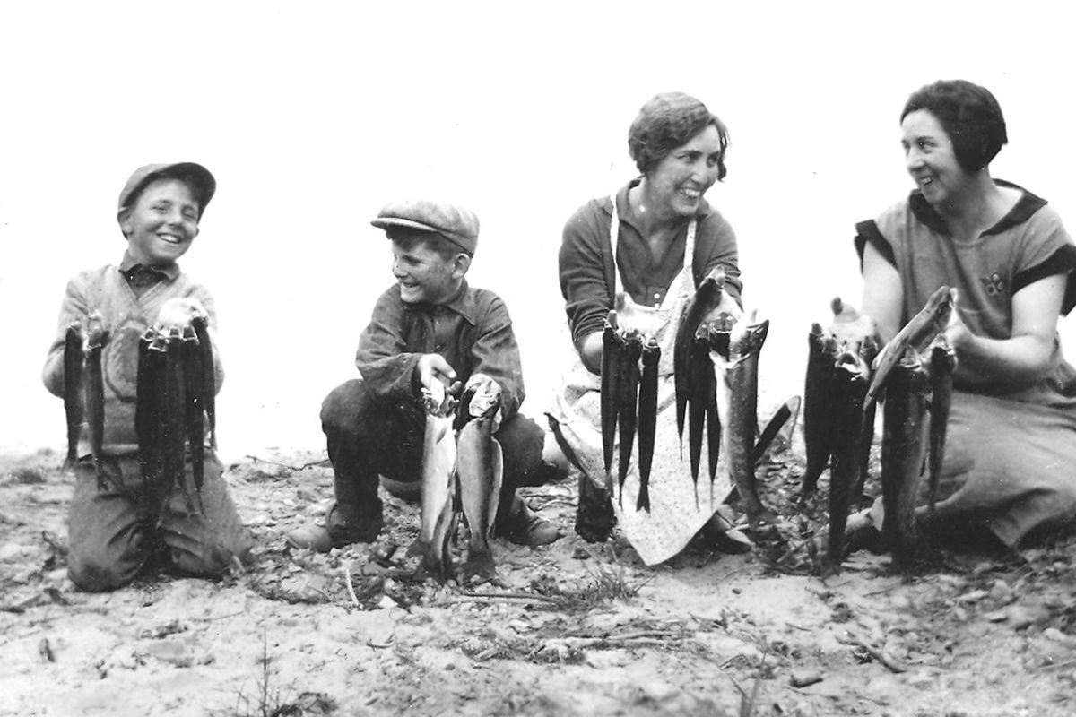 Iowa King Cowan, far right, shows off fish with other family members on the shores of a lake near Spokane, circa 1928.