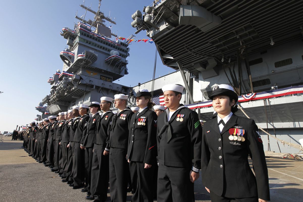 The crew of the USS Enterprise stands at attention after disembarking the ship during the inactivation ceremony for the first nuclear powered aircraft carrier USS Enterprise at Naval Station Norfolk Saturday, Dec. 1, 2012 in Norfolk, Va. The ship served in the fleet for 51 years. (Steve Helber / Associated Press)