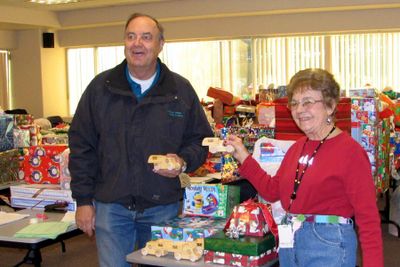 Patricia Kimmons, 83, has volunteered for the Children’s Administration’s Holiday Project since 1991. Here, she’s receiving the a donation of wooden trucks and trains from the Hoo-Hoo Club and presented by Gene Olson. Photo courtesy of Children’s Admistration (Photo courtesy of Children’s Admistration / The Spokesman-Review)